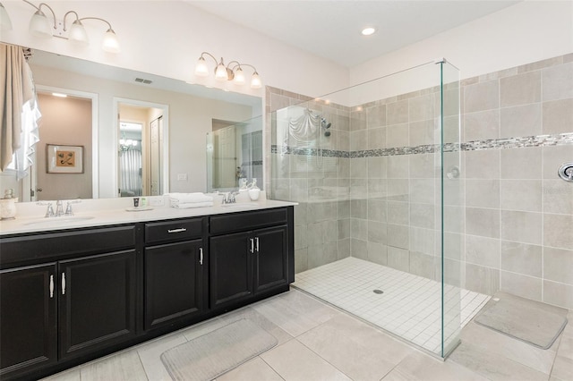 bathroom featuring dual vanity, tile patterned floors, and walk in shower