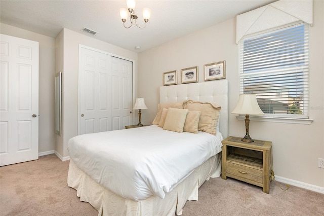 bedroom with a notable chandelier, light colored carpet, and a closet