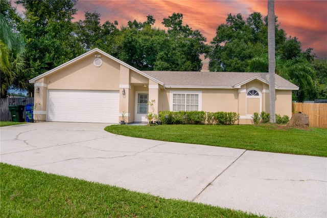 ranch-style home featuring a garage and a yard