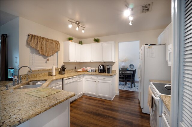 kitchen with rail lighting, white appliances, dark wood-type flooring, light stone countertops, and sink