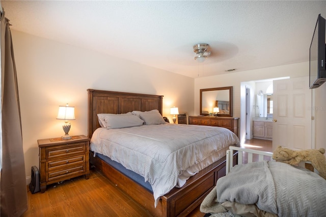 bedroom featuring ensuite bathroom, ceiling fan, and hardwood / wood-style flooring