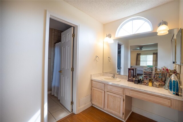 bathroom featuring a textured ceiling, vanity, a wealth of natural light, and hardwood / wood-style floors