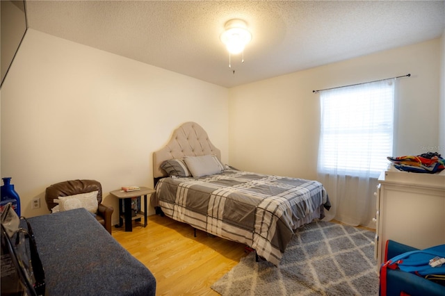 bedroom with a textured ceiling and light wood-type flooring