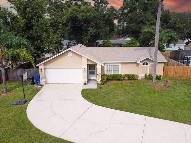 ranch-style house featuring a garage and a lawn