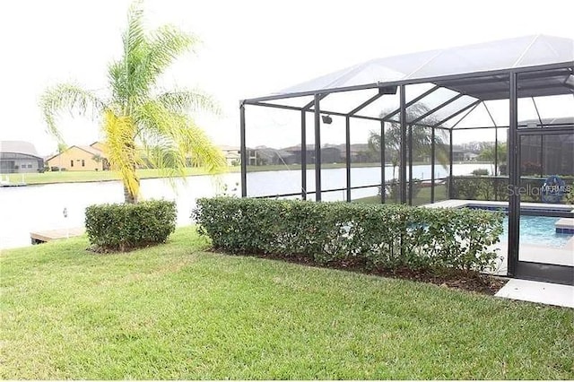 view of yard featuring glass enclosure and a water view