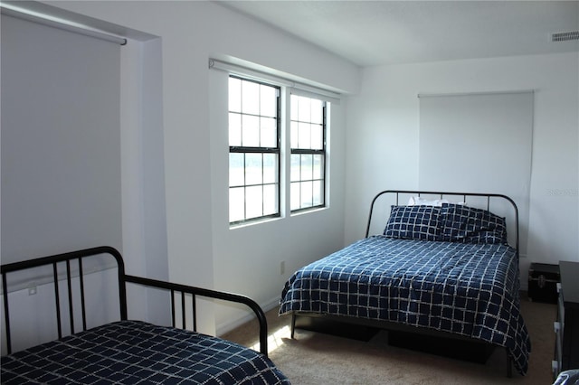 bedroom with carpet floors and multiple windows