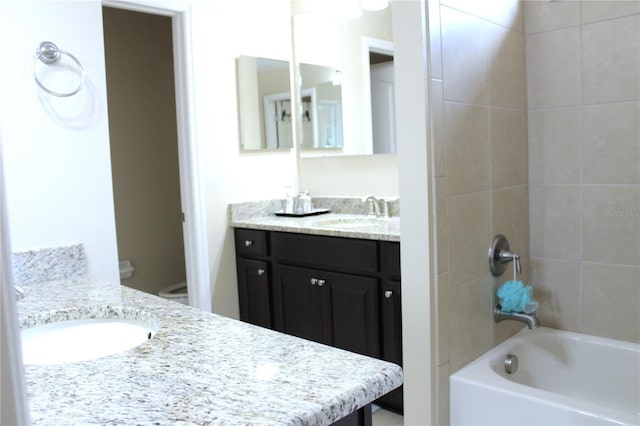 full bathroom featuring toilet, tiled shower / bath combo, and vanity