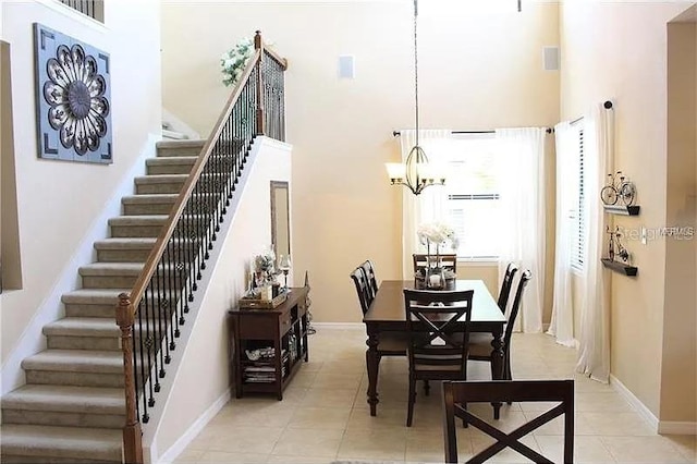 tiled dining space with a chandelier and a towering ceiling