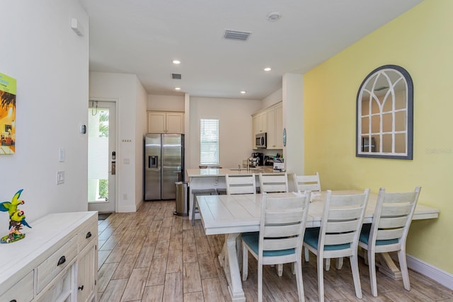 dining area with sink and light wood-type flooring