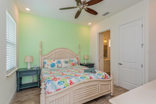 bedroom featuring ensuite bath, wood-type flooring, and ceiling fan