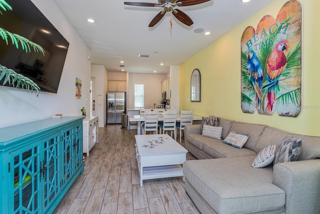 living room featuring ceiling fan and light hardwood / wood-style flooring