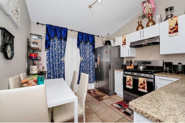 kitchen featuring light tile patterned floors, tasteful backsplash, appliances with stainless steel finishes, under cabinet range hood, and white cabinetry