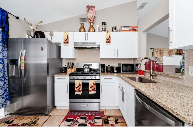 kitchen featuring under cabinet range hood, stainless steel appliances, a sink, vaulted ceiling, and tasteful backsplash