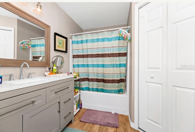 full bathroom featuring shower / tub combo, vanity, a textured ceiling, and wood finished floors