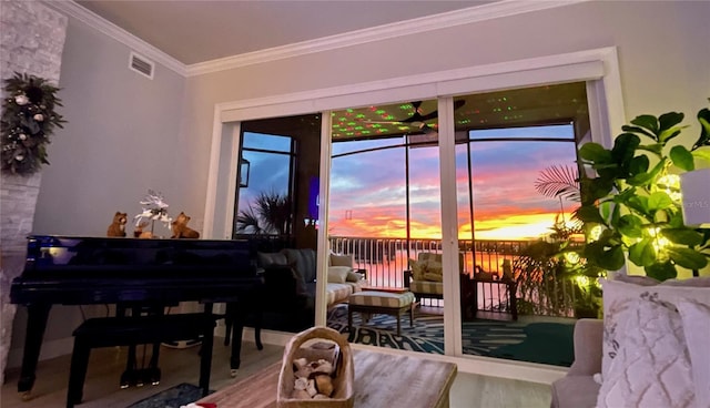 sitting room with visible vents, wood finished floors, and ornamental molding