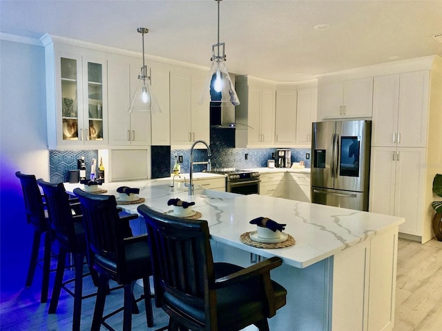 kitchen with decorative backsplash, glass insert cabinets, appliances with stainless steel finishes, light wood-type flooring, and white cabinetry