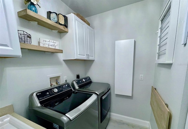 washroom with washing machine and clothes dryer, cabinet space, and baseboards