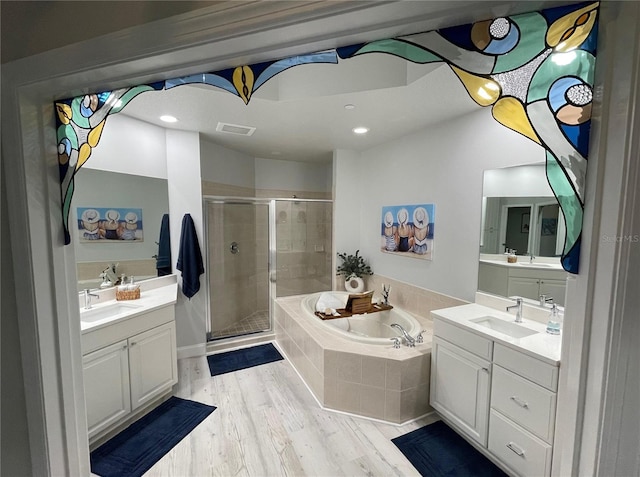 full bath with a garden tub, a shower stall, a sink, and wood finished floors