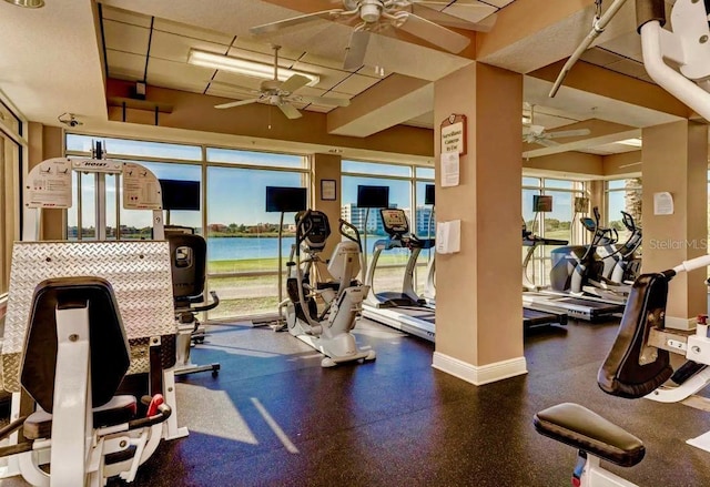 gym featuring ceiling fan and baseboards