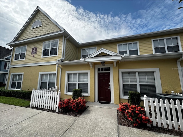 view of front of property with fence and stucco siding