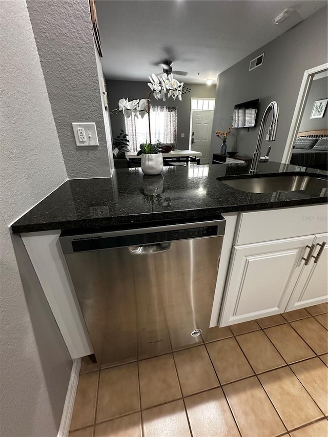 kitchen with visible vents, white cabinets, dishwasher, dark stone countertops, and a sink