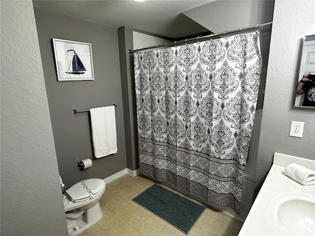 full bathroom with toilet, baseboards, and vanity