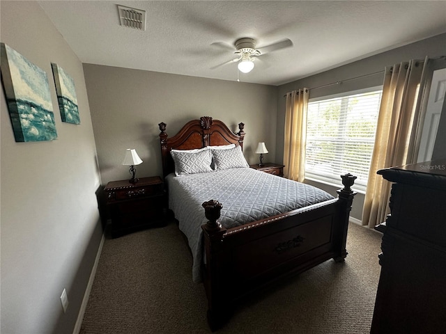 bedroom featuring baseboards, visible vents, dark colored carpet, and a textured ceiling