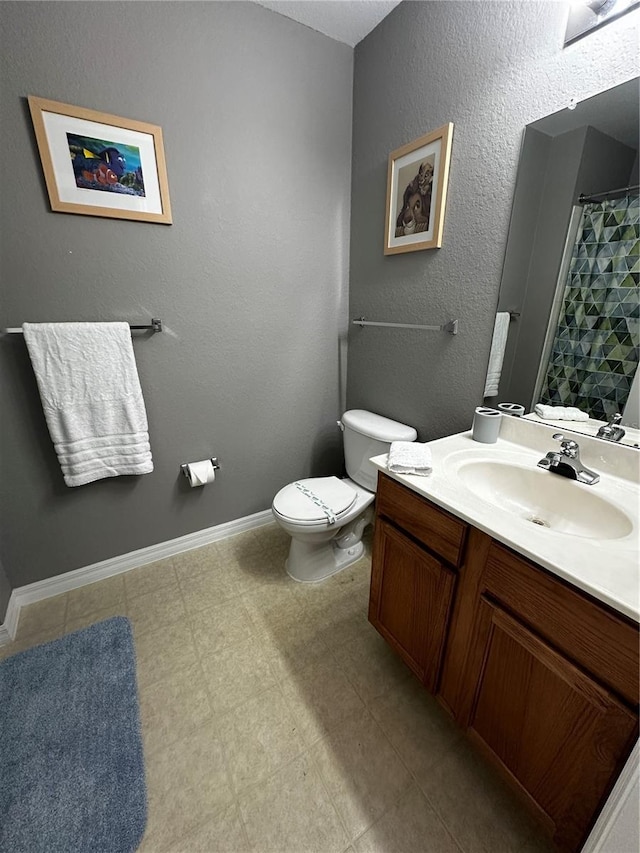 bathroom with baseboards, a textured wall, toilet, tile patterned floors, and vanity