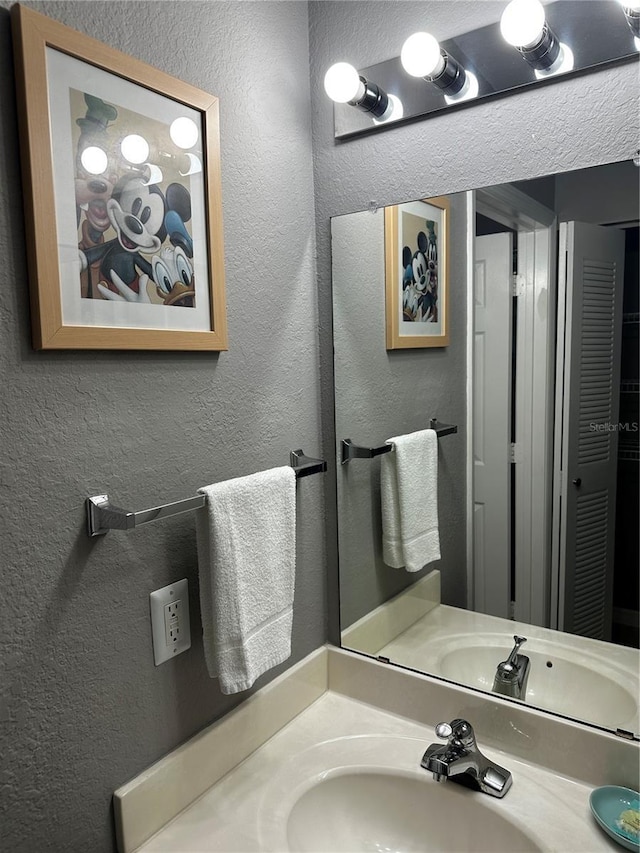 bathroom featuring vanity and a textured wall