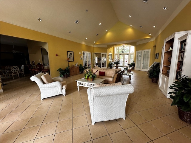 living room featuring light tile patterned floors, ceiling fan, visible vents, and high vaulted ceiling