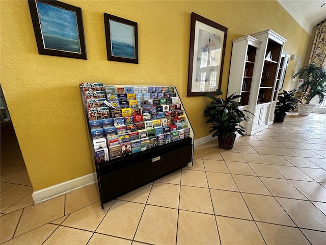 interior space with light tile patterned floors and baseboards