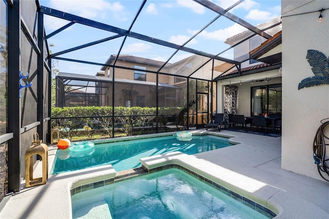 view of pool featuring a pool with connected hot tub, glass enclosure, and a patio