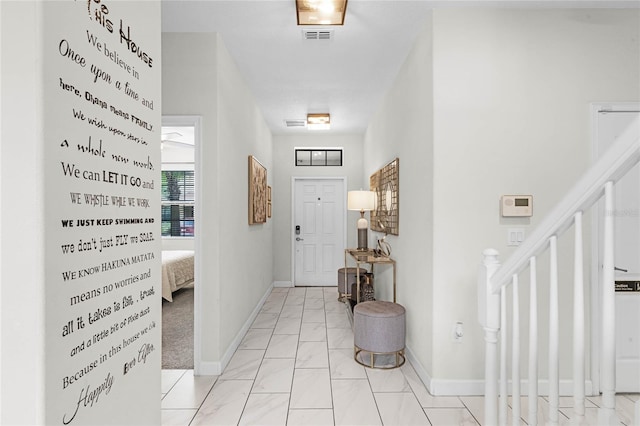 entrance foyer featuring marble finish floor, visible vents, stairway, and baseboards