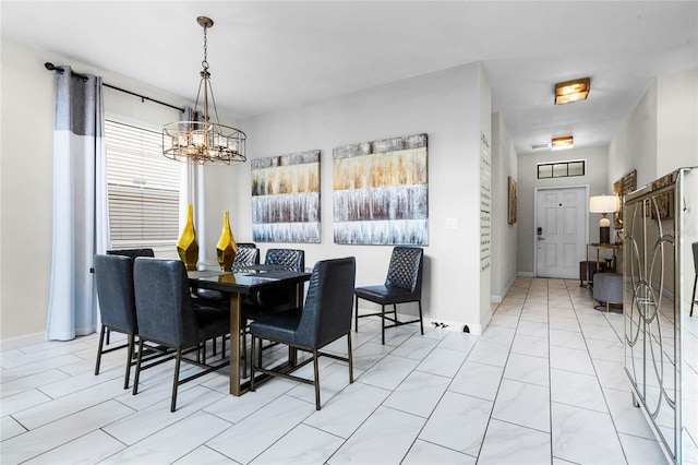 dining space featuring an inviting chandelier and baseboards