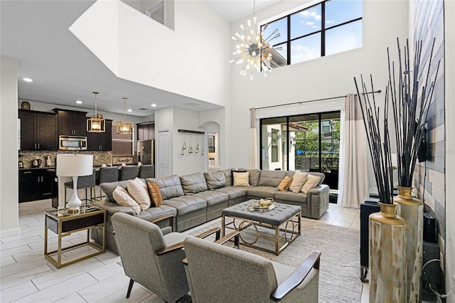 living area with a chandelier, arched walkways, and recessed lighting