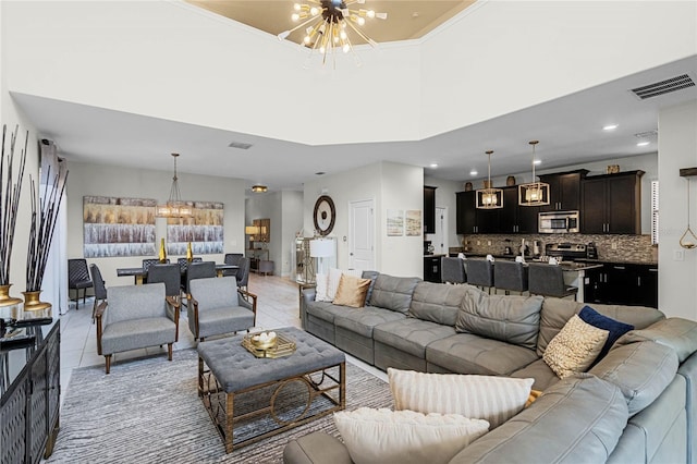 living room with visible vents, a notable chandelier, and light tile patterned flooring