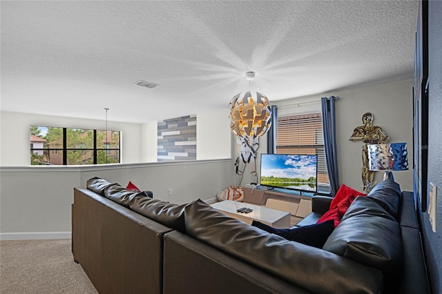 carpeted living room with visible vents, a textured ceiling, and baseboards