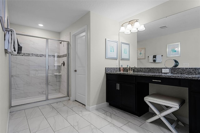 full bathroom featuring marble finish floor, baseboards, vanity, and a shower stall