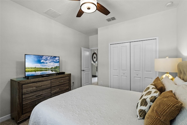 bedroom with carpet floors, visible vents, baseboards, a ceiling fan, and a closet