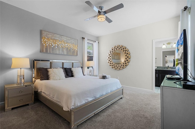 bedroom with a ceiling fan, baseboards, dark colored carpet, and connected bathroom