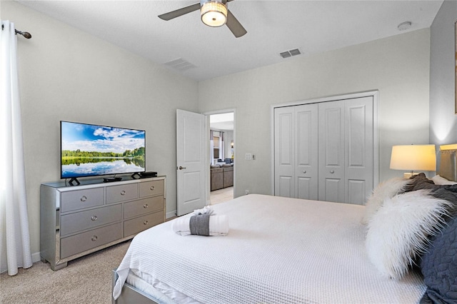 bedroom featuring ceiling fan, a closet, visible vents, and light colored carpet