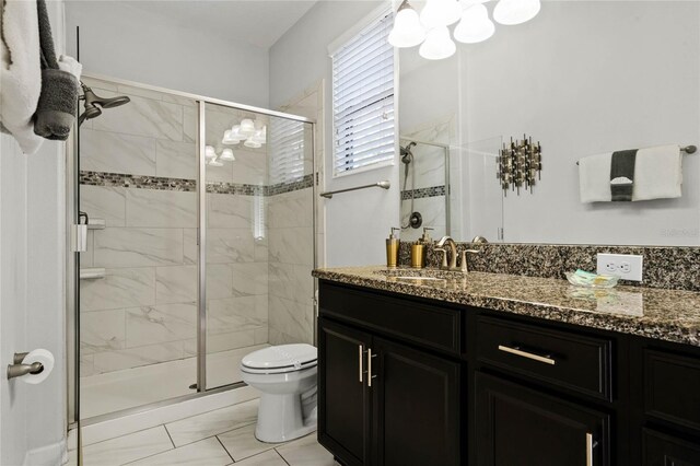 bathroom featuring toilet, a shower stall, and vanity