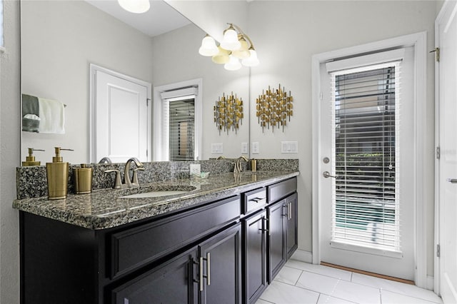 bathroom with double vanity, a sink, and tile patterned floors