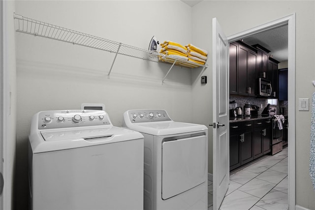 washroom with marble finish floor, washing machine and clothes dryer, and laundry area