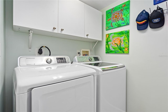 clothes washing area with cabinet space and washer and clothes dryer