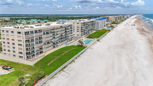 birds eye view of property with a water view and a beach view