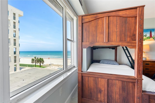 bedroom with a water view and a beach view