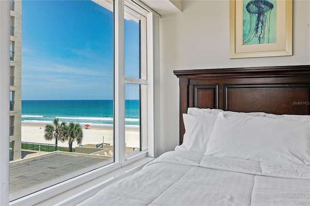 bedroom with a water view and a view of the beach