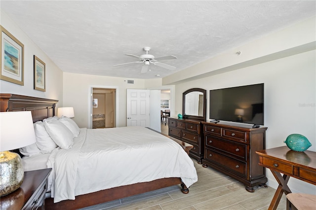 bedroom with wood tiled floor, visible vents, ceiling fan, and a textured ceiling