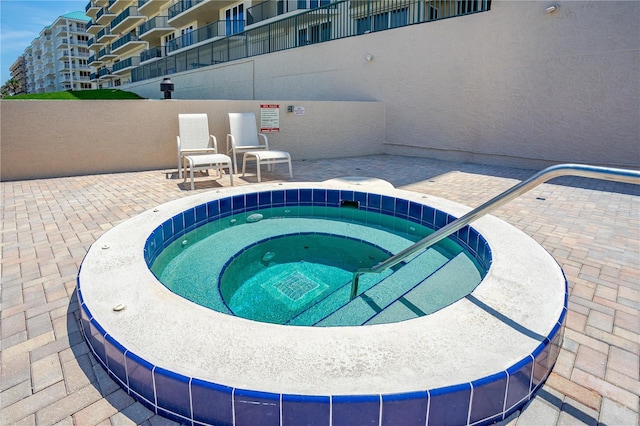 view of pool featuring a community hot tub and a patio area